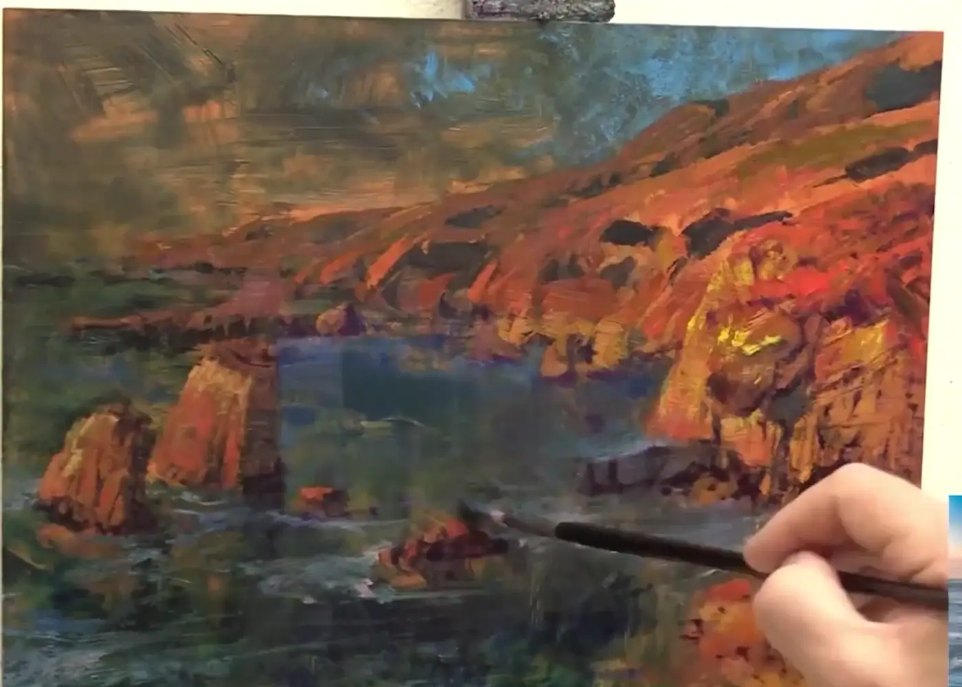 A brush placing clean paint into a colorful wet passage during Bill Inman's muddy-paint demonstration.
